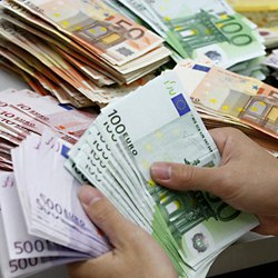 A bank employee counts Euro notes at Kasikornbank in Bangkok